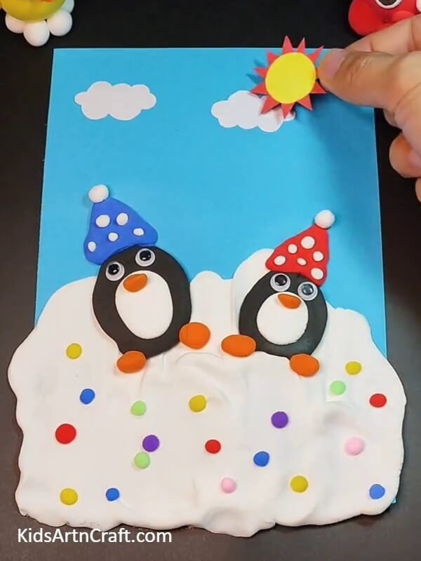 Making clouds and sun using color paper- An Easy-to-Follow Guide To Crafting Cuddly Penguin Clay Creations For Kids